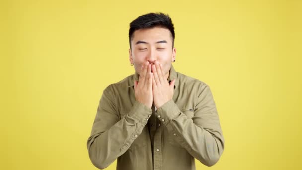 Китайський Молодий Чоловік Цілується Заплющеними Очима Студії Жовтим Фоном — стокове відео