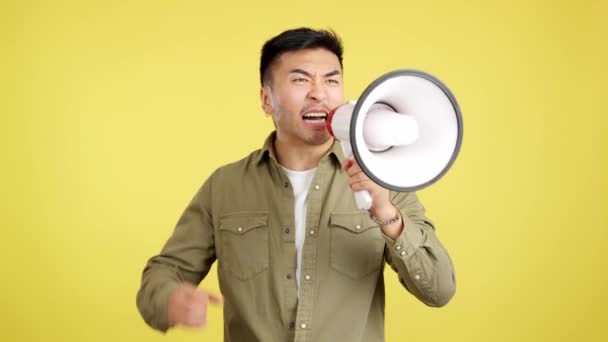 Wściekły Chińczyk Krzyczący Patrzący Kamerę Pomocą Głośnika Studio Żółtym Tłem — Wideo stockowe