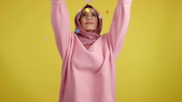 Glad Muslimsk Kvinna Omgiven Konfetti Flyger Luften Studio Med Gul — Stockvideo