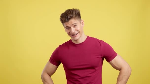 Stüdyoda Sarı Arka Planda Kameraya Gülümseyen Parantezli Yakışıklı Bir Adam — Stok video
