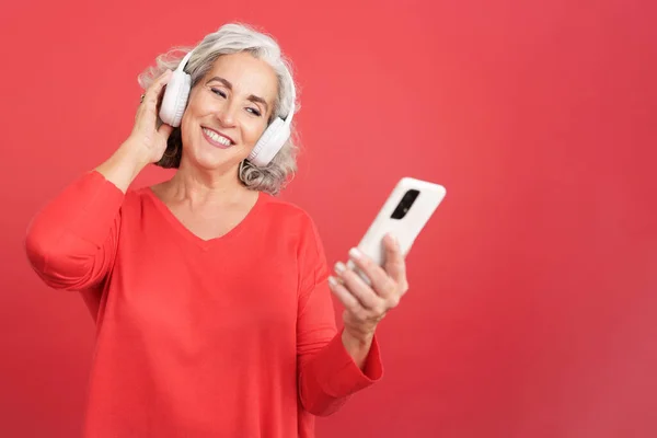 Retrato Estudio Con Fondo Rojo Una Mujer Madura Escuchando Música —  Fotos de Stock