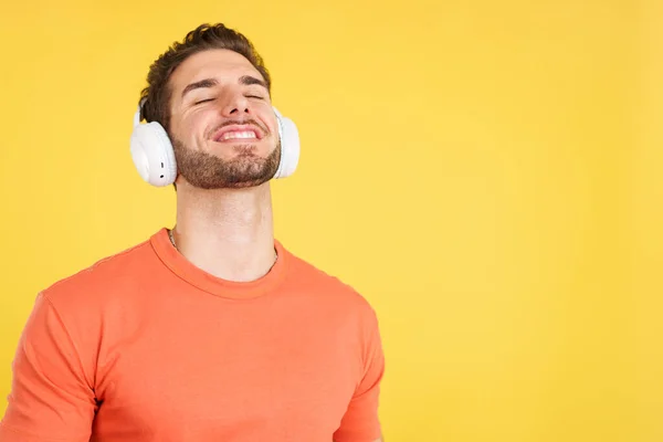 Relaxed Caucasian Man Listening Music Headphones Studio Yellow Background — Stock Photo, Image