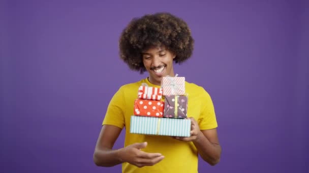 Smiley African Man Curly Hair Holding Many Gifts While Looking — Stock Video