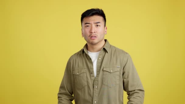 Китайська Людина Жестикулює Руками Страху Студії Жовтим Фоном — стокове відео