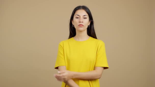 茶色い背景のスタジオで怒りの表情で腕を横断する白人女性 — ストック動画