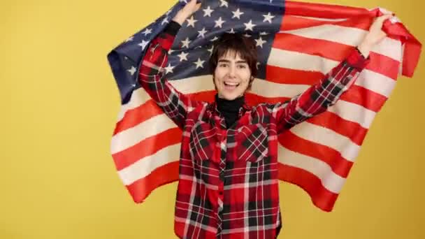 Androgyn Person Som Hissar Amerikansk Flagga Studio Med Gul Bakgrund — Stockvideo