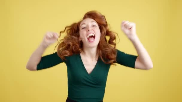 Boldog Vörös Hajú Ünnepli Felemeli Öklét Stúdióban Sárga Háttér — Stock videók