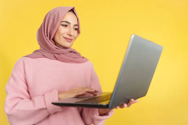 Mulher Muçulmana Feliz Usando Laptop Estúdio Com Fundo Amarelo — Fotografia de Stock