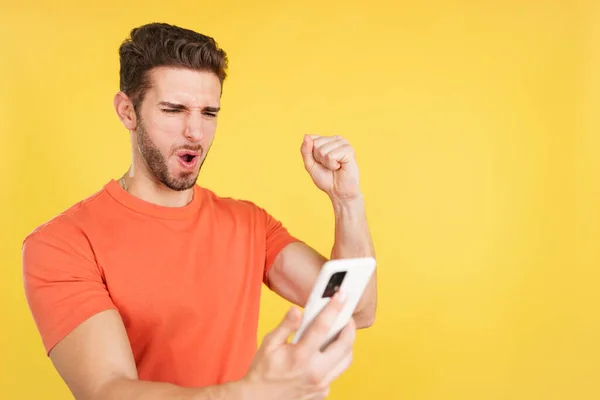 Emocionado Hombre Caucásico Celebrando Mientras Utiliza Teléfono Móvil Estudio Con — Foto de Stock