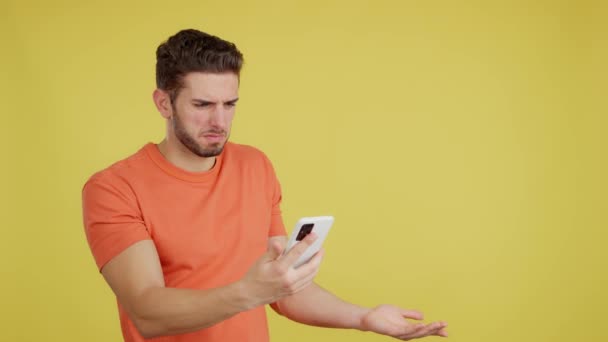 Worried Caucasian Man Using Mobile Phone Studio Yellow Background — Stockvideo