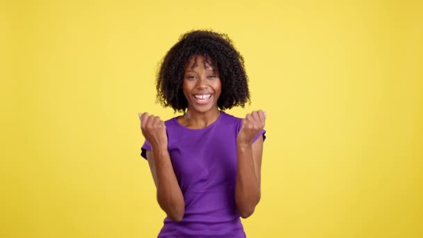 Happy Woman Afro Hair Celebrating While Raising Fists Studio Yellow — Vídeo de Stock