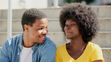 Sokakta birlikte oturan Afrikalı bir çiftin hassas sahnesinin yavaş çekim videosu.