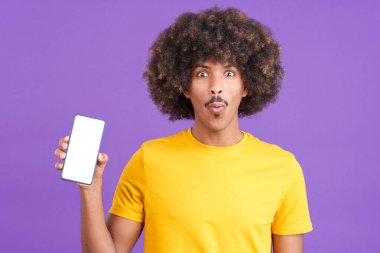 Stüdyoda boş ekranlı cep telefonu tutan sürpriz Afrikalı adam.