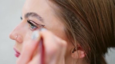 Yavaş çekim. Sahne arkasında kadının göz makyajı videosu.