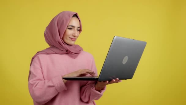 Mulher Muçulmana Feliz Celebrando Usar Laptop Estúdio Com Fundo Amarelo — Vídeo de Stock