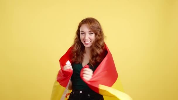Ευτυχισμένη Κοκκινομάλλα Γυναίκα Τυλίγεται Μια Ισπανική Εθνική Σημαία Στο Στούντιο — Αρχείο Βίντεο