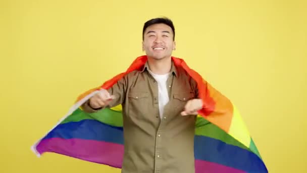 Feliz Hombre Chino Envolviendo Con Una Bandera Arco Iris Lgbt — Vídeos de Stock