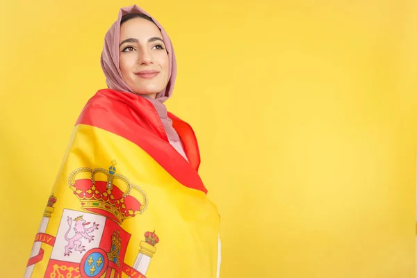 Dreamy Muslim Woman Wrapped Spanish National Flag Studio Yellow Background — Stock Photo, Image