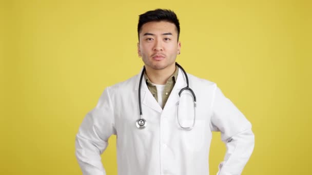Kinesisk Läkare Ler Mot Kameran Studio Med Gul Bakgrund — Stockvideo