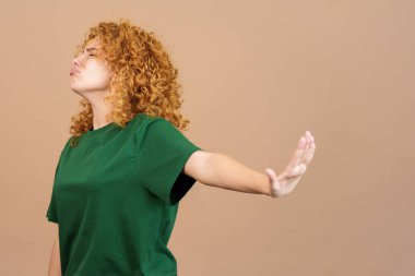 Stüdyo görüntüsü kıvırcık saçlı ve sıradan giyinen genç bir kadın hiçbir şey bilmek istemiyor.