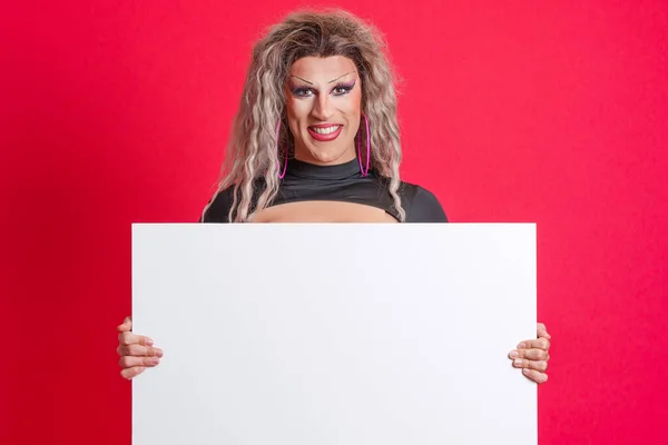 stock image Smiley transgender person with make up holding a blank panel in studio with red background