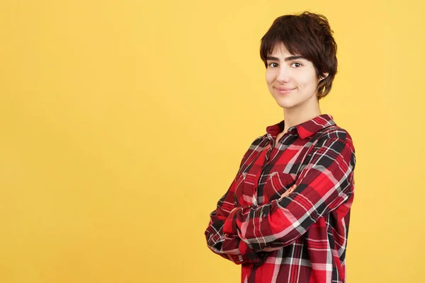 Androgynous Person Smiling Camera Arms Crossed Studio Yellow Background — Stock Photo, Image