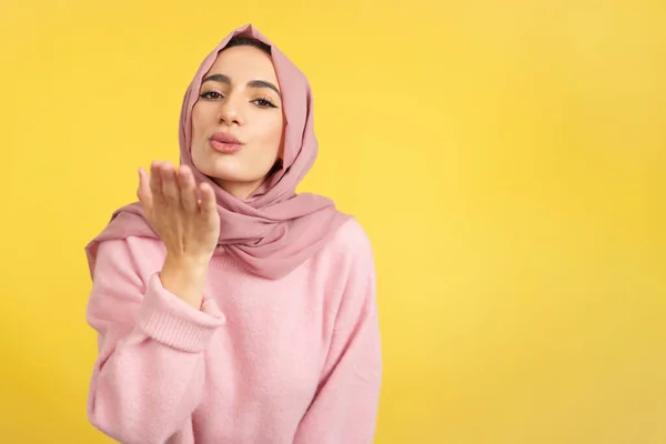 Muslim Woman Blowing Kiss While Looking Camera Studio Yellow Background — Stock Photo, Image
