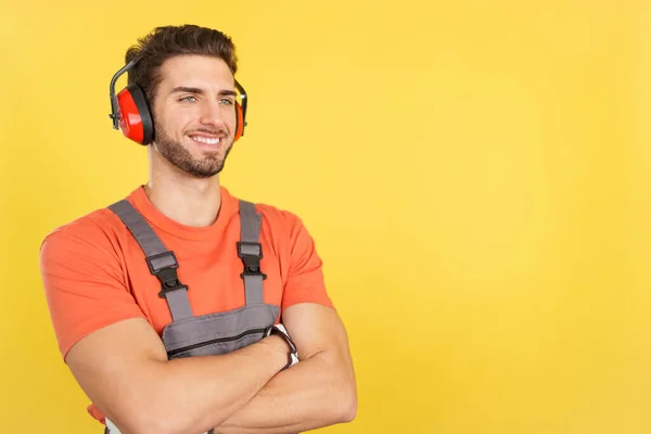 Distracted Caucasian Male Carpenter Looking Away Arms Crossed Studio Yellow — Stock Photo, Image