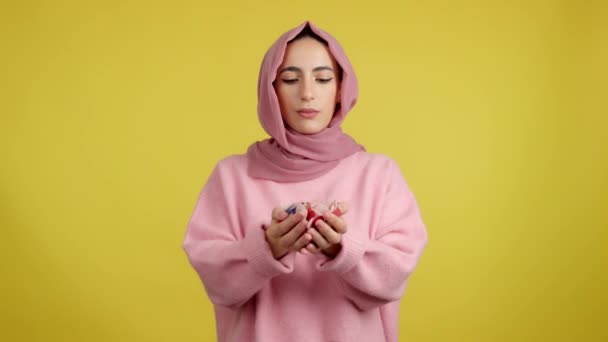 Studio Portret Żółtym Tle Muzułmanki Patrząc Aparat Dmuchając Confetti — Wideo stockowe