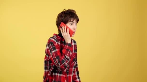 Stüdyoda Sarı Arka Planlı Cep Telefonuyla Konuşan Çift Cinsiyetli Kişi — Stok video