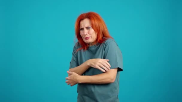 Mature Redheaded Woman Looking Camera Gesturing She Cold Studio Blue — Stock Video