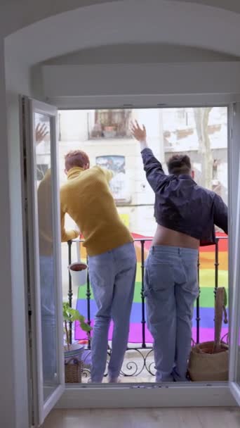 两个同性恋男子从阳台上挥动国旗的后视镜的垂直慢镜头 — 图库视频影像
