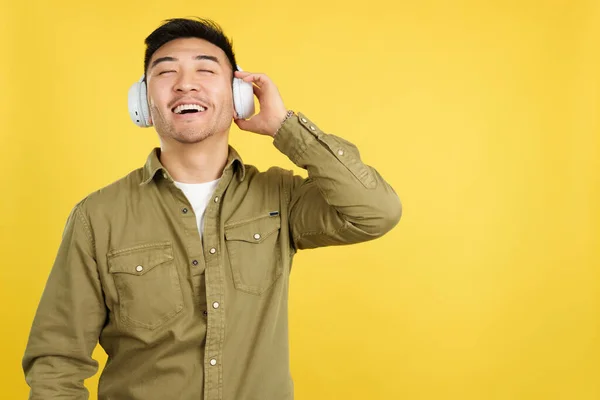 Relaxed Chinese Man Listening Music Headphones Connected Mobile Studio Yellow — Stock Photo, Image