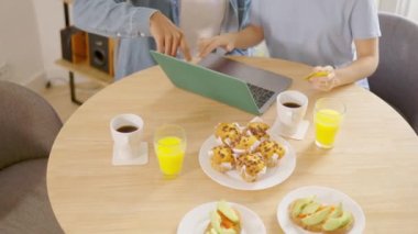 İnternetten alışveriş yapan çok ırklı bir çiftin kahvaltı edişinin yavaş çekim videosu.