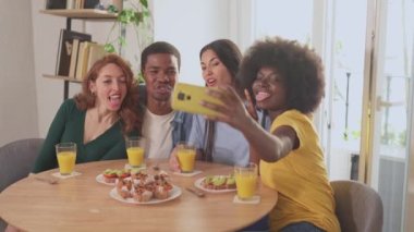 Çok ırklı arkadaşların kahvaltıda selfie çekerken eğlendikleri yavaş çekim videoları.
