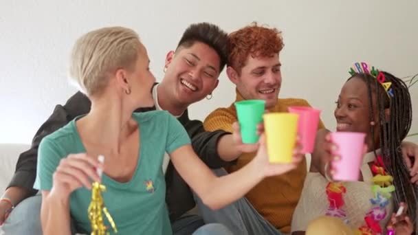 スローモーションビデオの多民族グループの友人トーストと笑いながら家でお祝い — ストック動画