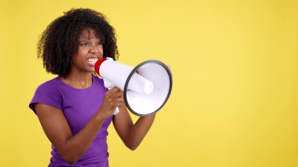 Stüdyoda Sarı Arka Planda Megafon Kullanan Afrikalı Bir Kadın Bağırıyor — Stok video