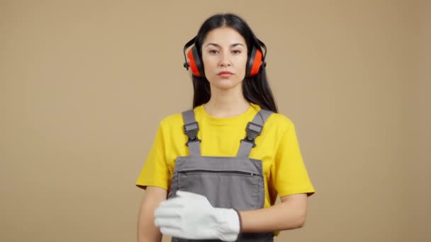 Poważna Pracownica Stojąca Skrzyżowanymi Rękami Patrząca Kamerę Tło Brązowe — Wideo stockowe