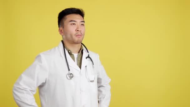 Vänlig Kinesisk Läkare Uniform Och Stetoskop Studio Med Gul Bakgrund — Stockvideo