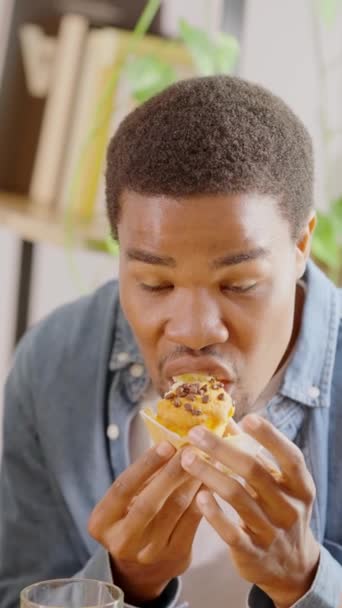 影片中 一个快乐的非洲男人一边在家里吃蛋糕一边笑 慢条斯理地拍了下来 — 图库视频影像