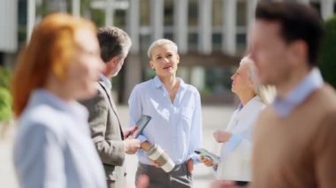 Sokakta sohbet eden bir grup iş adamının yavaş çekim videosu.