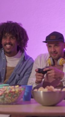 Konsol oynayan bir grup etnik kökenli arkadaşın yavaş çekim videosu ve içlerinden biri kazanıyor.