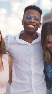 Sokakta yürürken gülümseyen üç kişi.