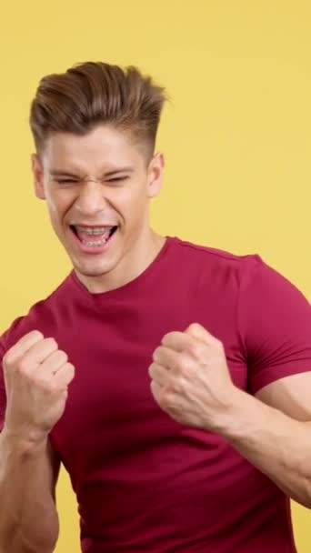 Чоловік Дужками Святкують Кулаками Піднятими Студії Жовтим Тлом — стокове відео