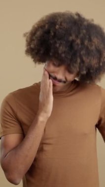 African man with curly hair and the hand on face and thoughtful expression in studio