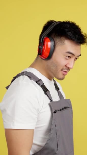 Chinese Carpenter Protective Gear Smiling Camera Studio Yellow Background — Vídeo de stock
