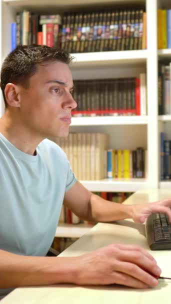 집에서 티셔츠를 남자가 컴퓨터 앞에서 필사적으로 일하고 있습니다 보이는 — 비디오