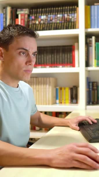 Mannen Shirt Som Telearbetar Hemifrån Koncentrerad Framför Datorn Bokhandel Bakgrunden — Stockvideo