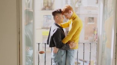 Yavaş çekim videosu, eşcinsel bir çiftin evdeki balkonda yüz yüze kucaklaştığı hassas bir sahneye yaklaşıyor.