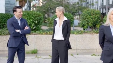 İş adamı ve iş kadınının açık havada konuşup gülümsediği yavaş çekim videoları.